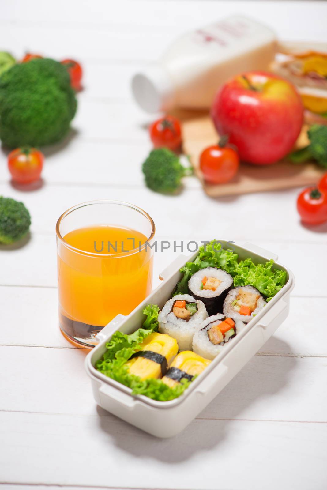 Orange juice and bento box with different food, fresh veggies an by makidotvn