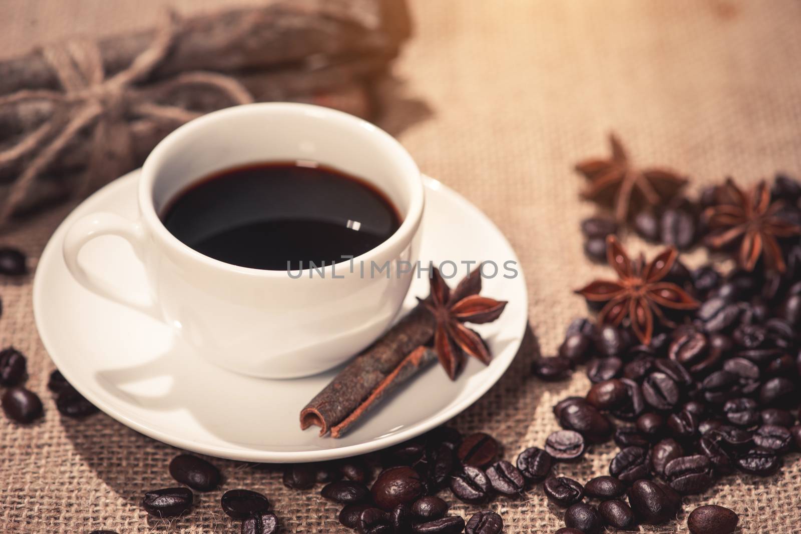 Coffee cup and coffee beans on table by makidotvn