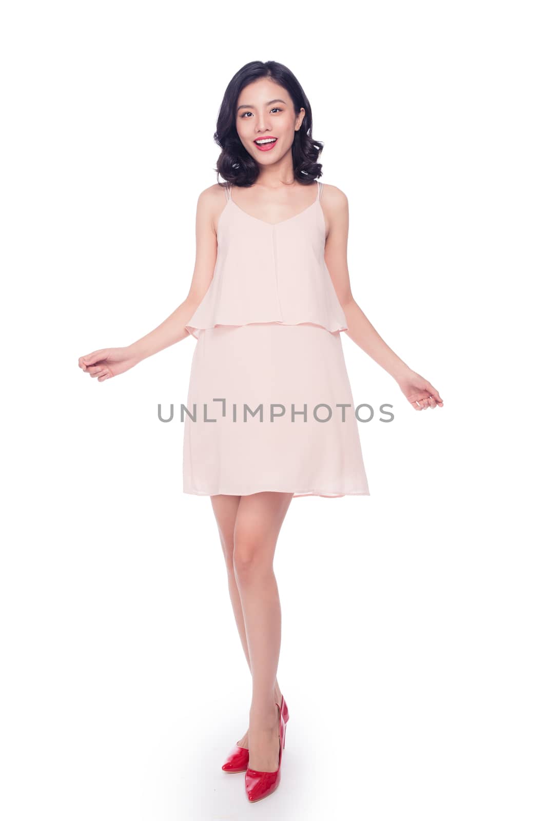 Beautiful happy cute asian woman in casual pink dress with red l by makidotvn