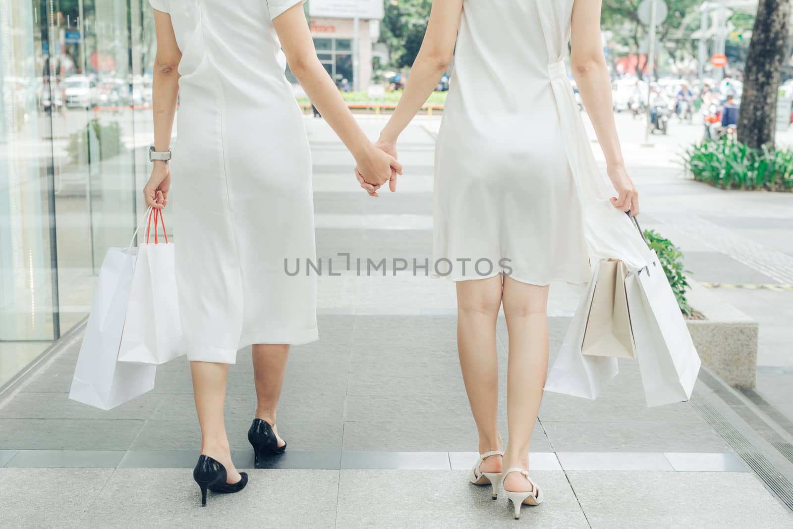 Beautiful asian girls with shopping bags walking on street at th by makidotvn