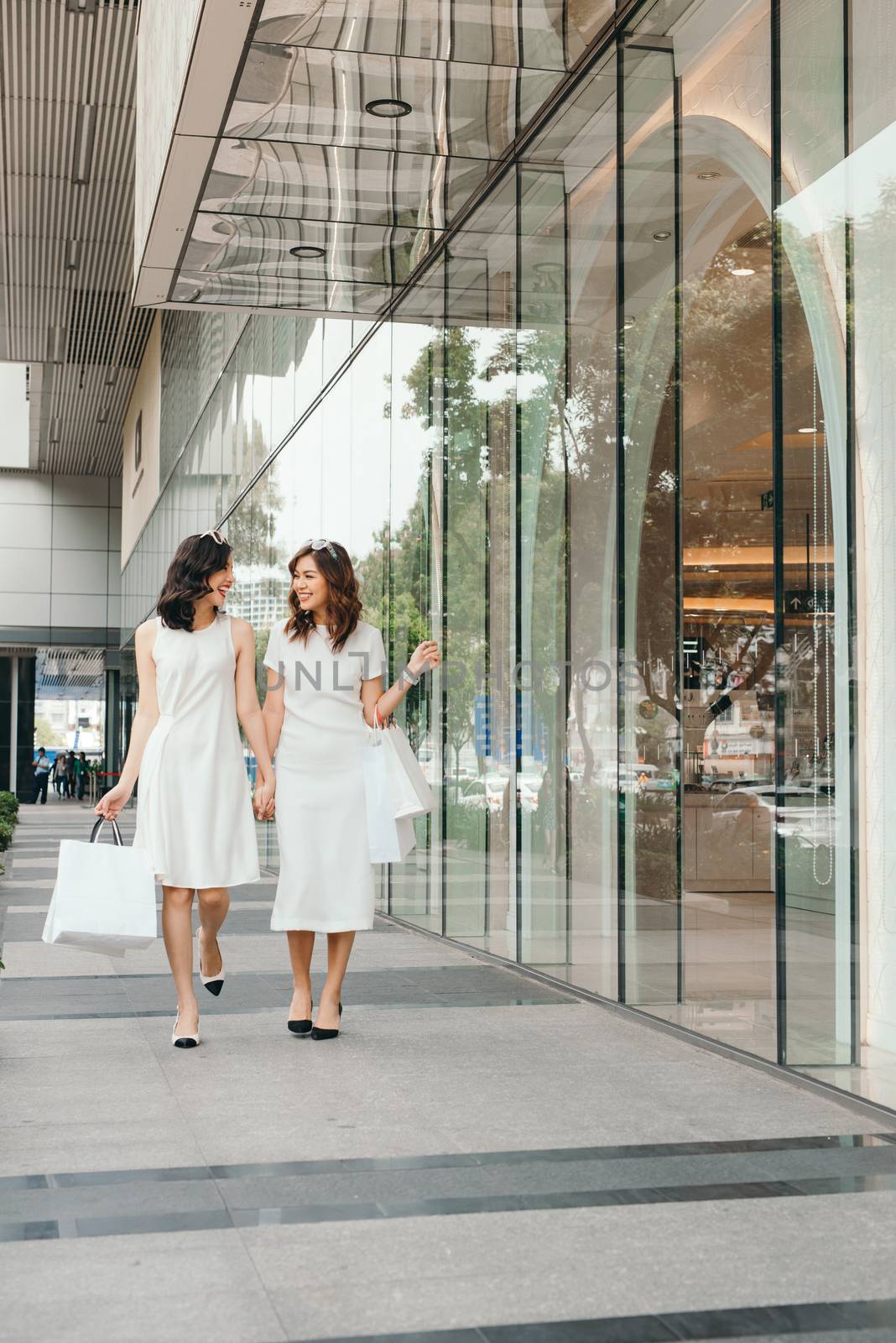 Beautiful asian girls with shopping bags walking on street at th by makidotvn