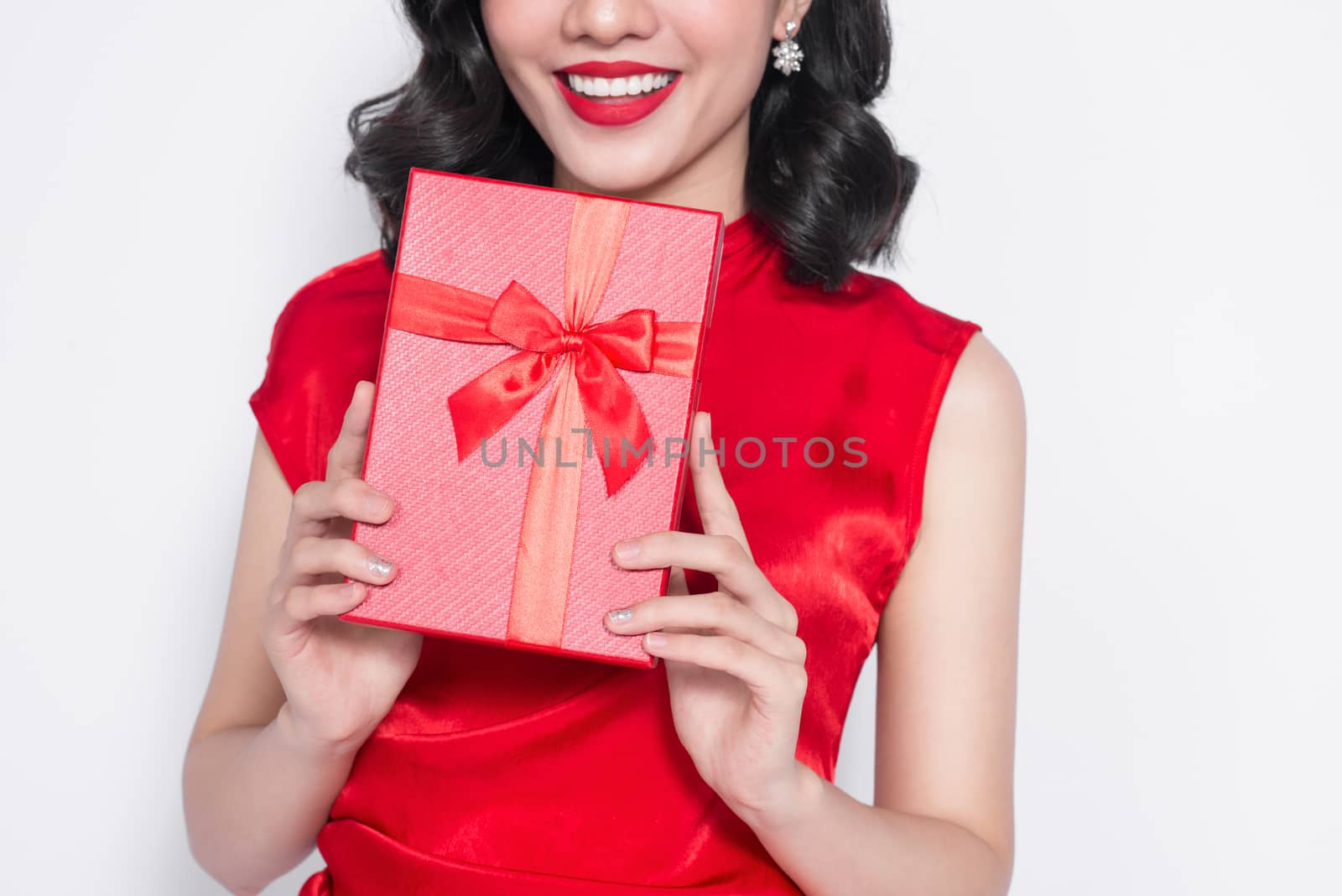 Pretty young asian woman dressed in red dress with a present by makidotvn