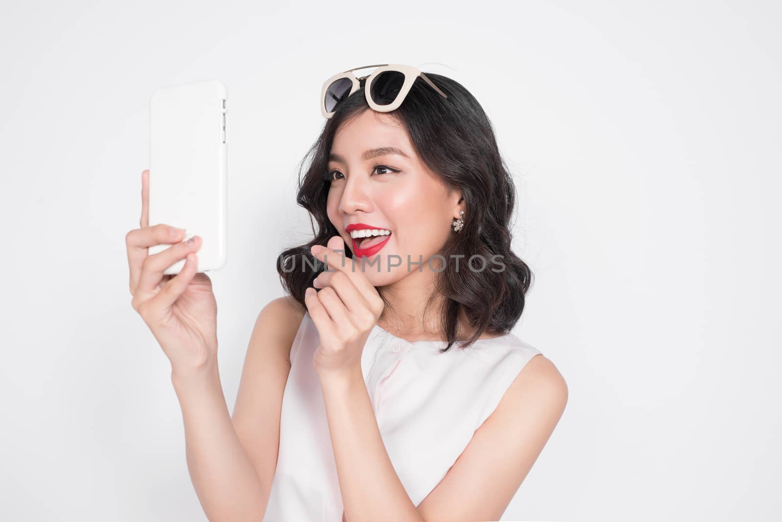 Portrait of beautiful asian fashionable girl taking selfie