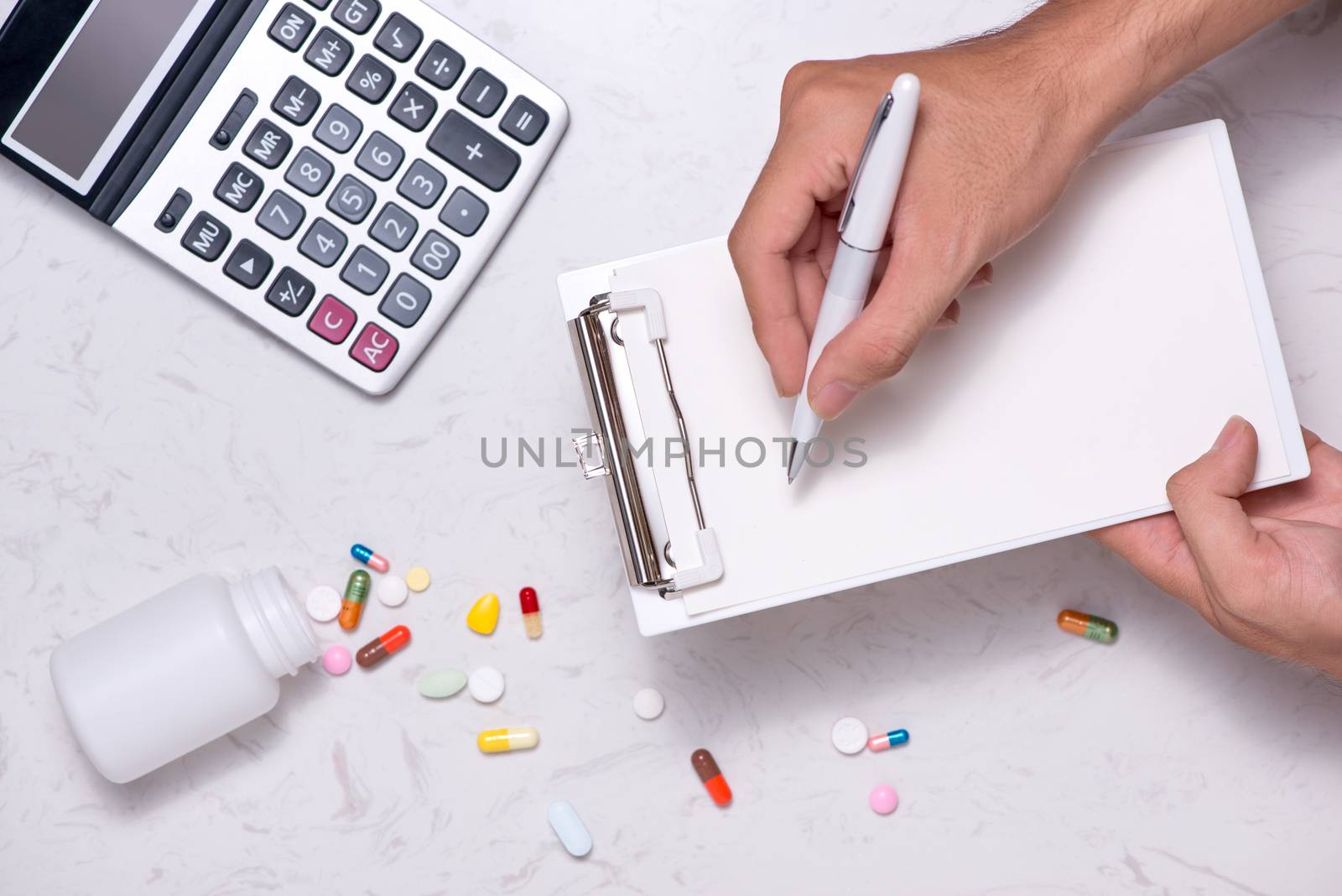 Healthcare costs concept. Opened medicine bottle and spilled out by makidotvn