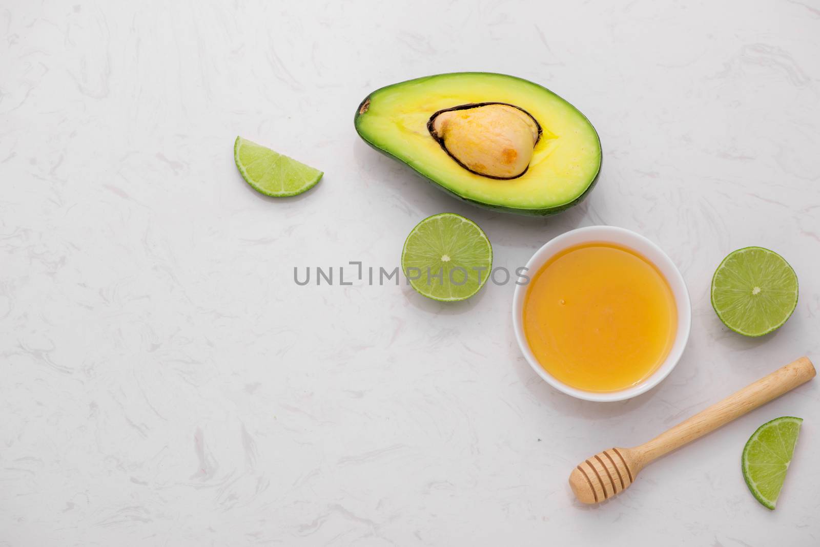 Healthy food concept. Fresh organic avocado and lime with honey on table