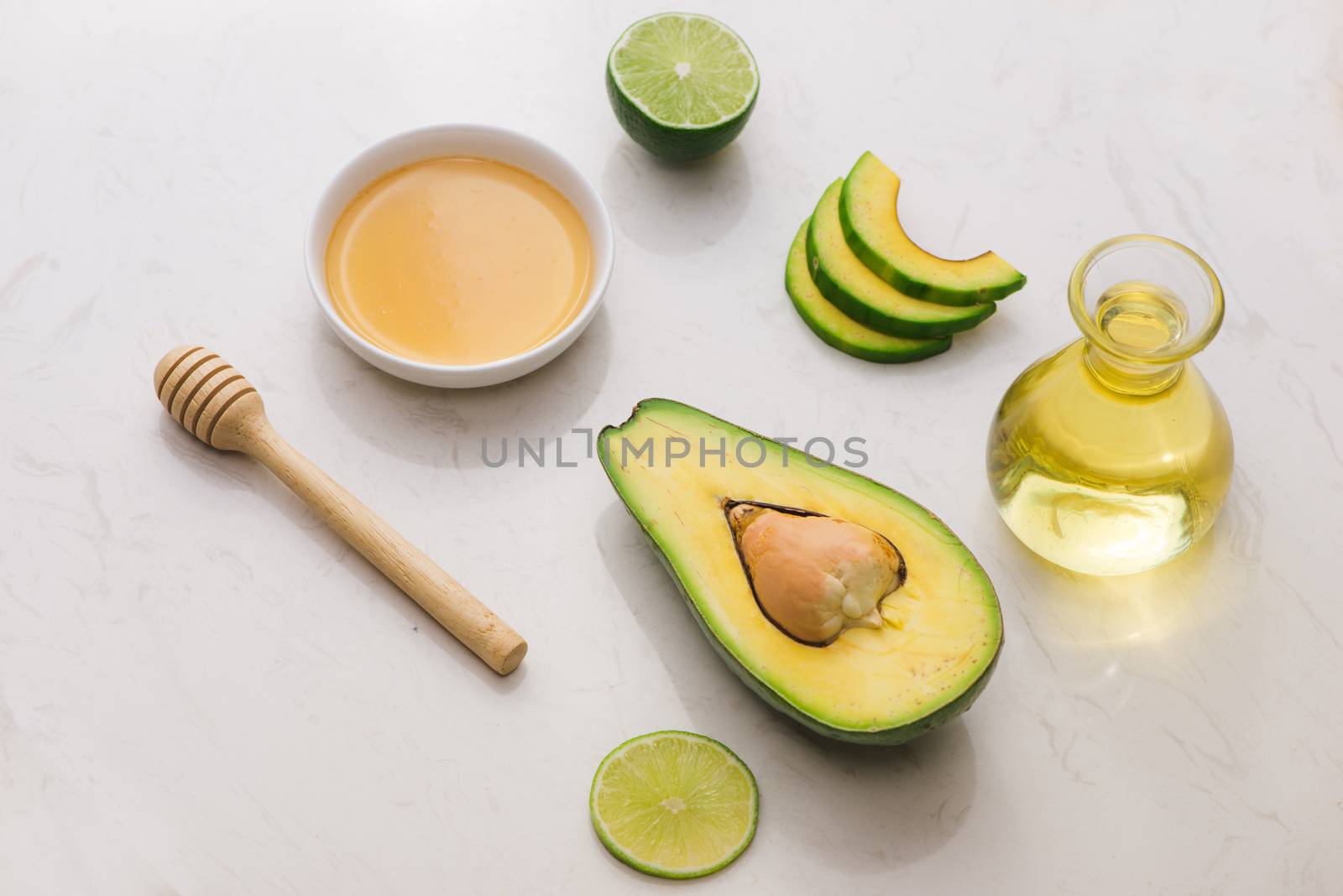 Healthy food concept. Fresh organic avocado oil and lime with honey on table