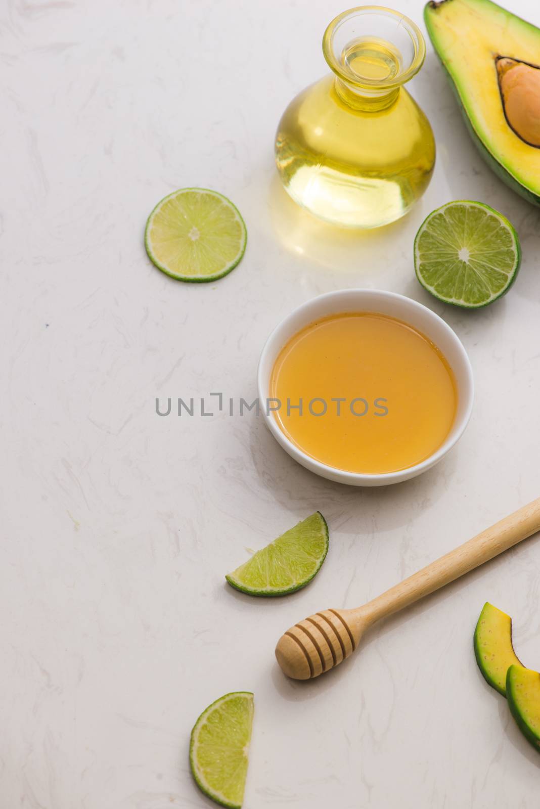 Healthy food concept. Fresh organic avocado oil and lime with honey on table