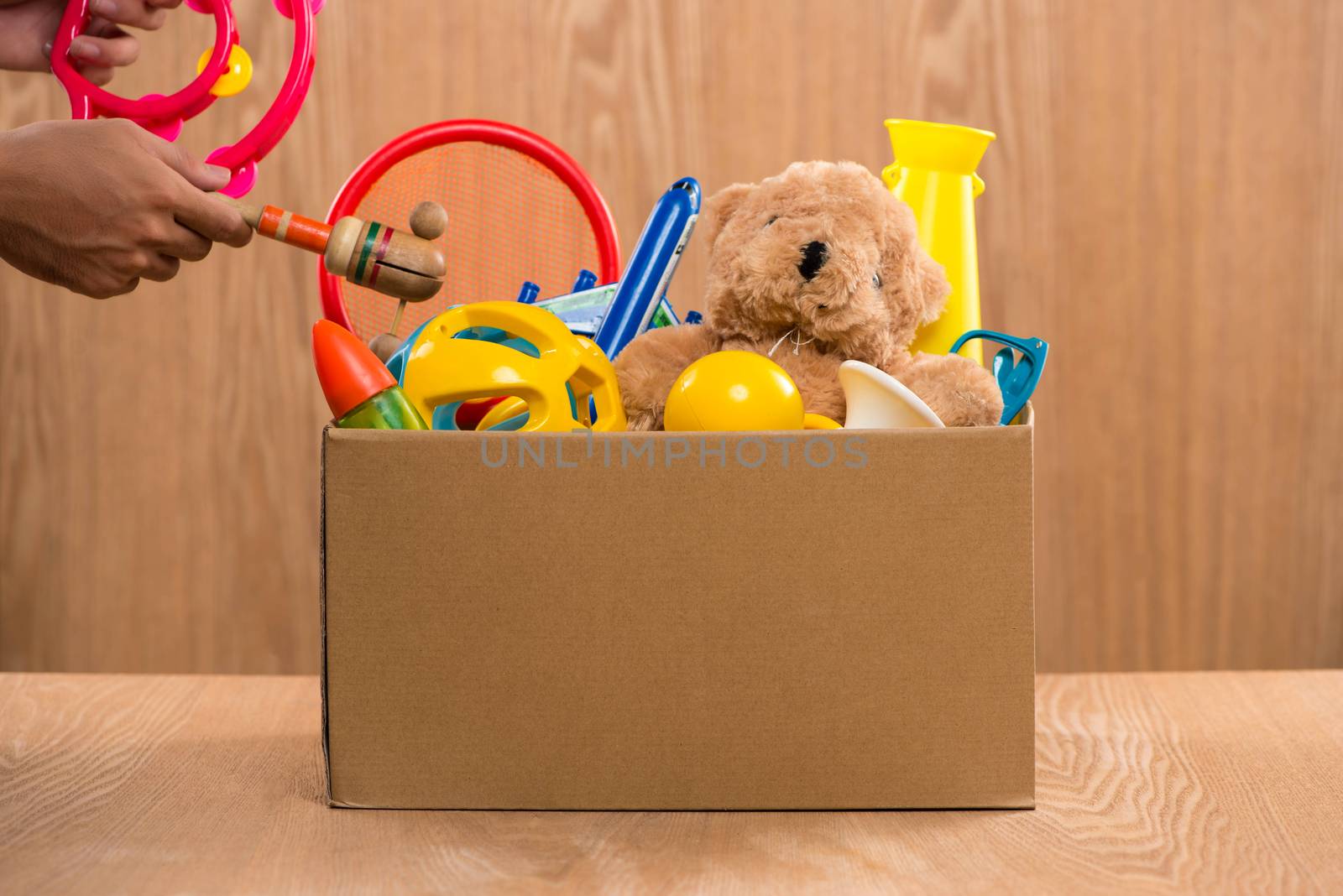 Male volunteer holding donation box with old toys. by makidotvn