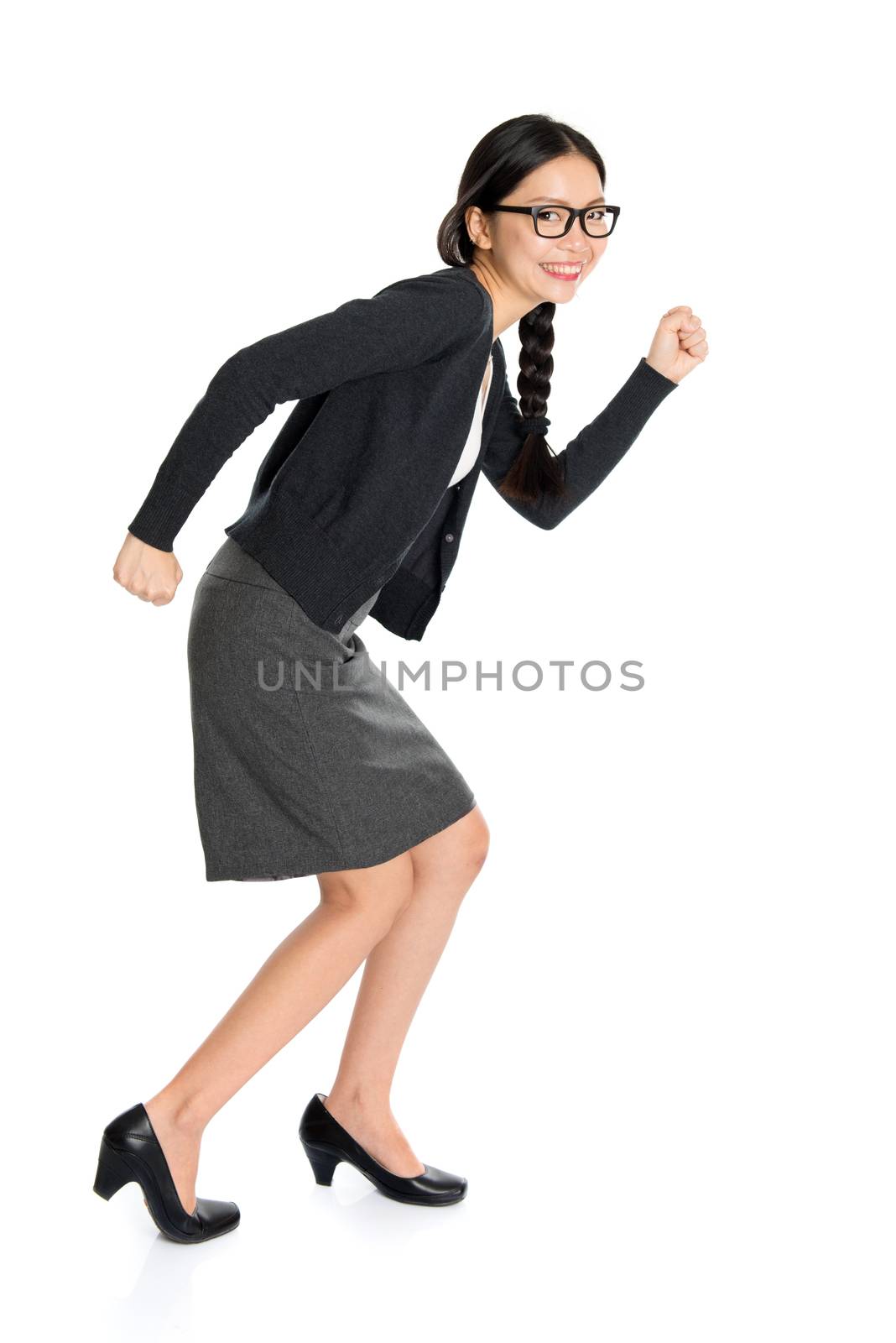 Full length portrait of young Asian girl running, isolated on white background.