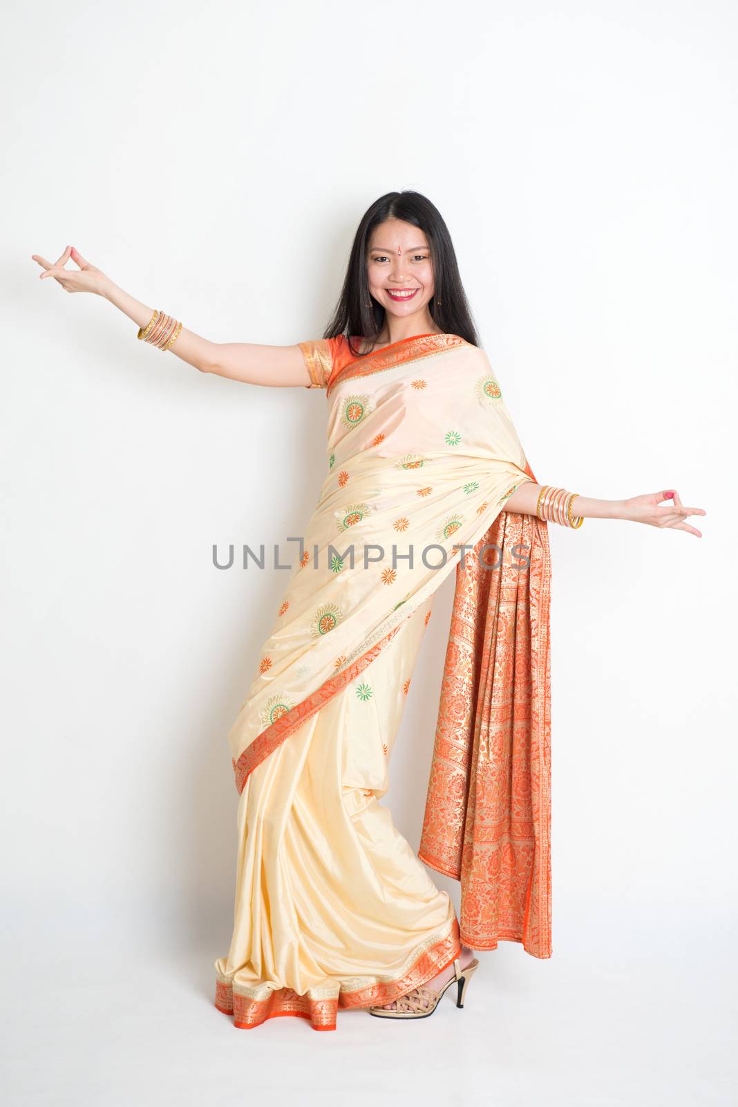 Young woman in Indian sari dress dancing by szefei