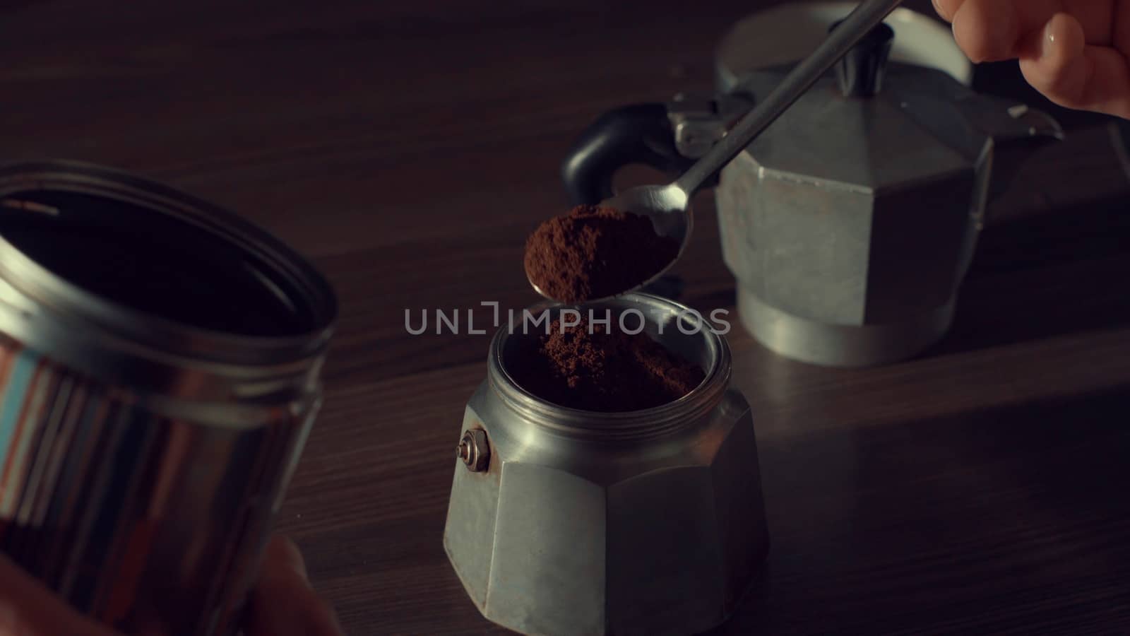 Close up of man's hand pouring coffee in a geyser