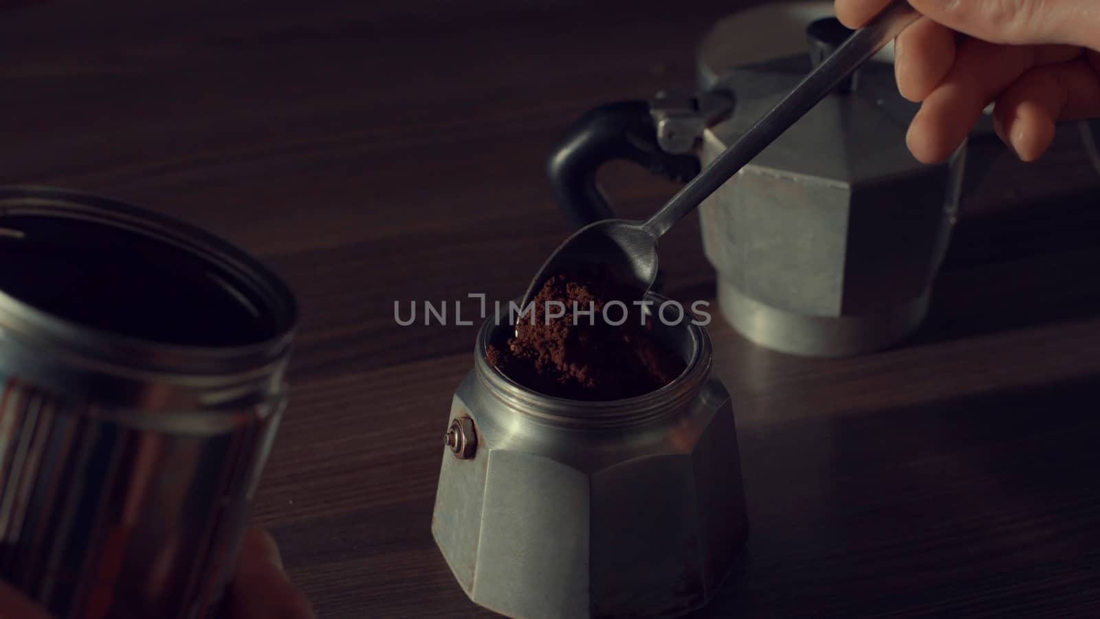 Close up of man's hand pouring coffee in a geyser