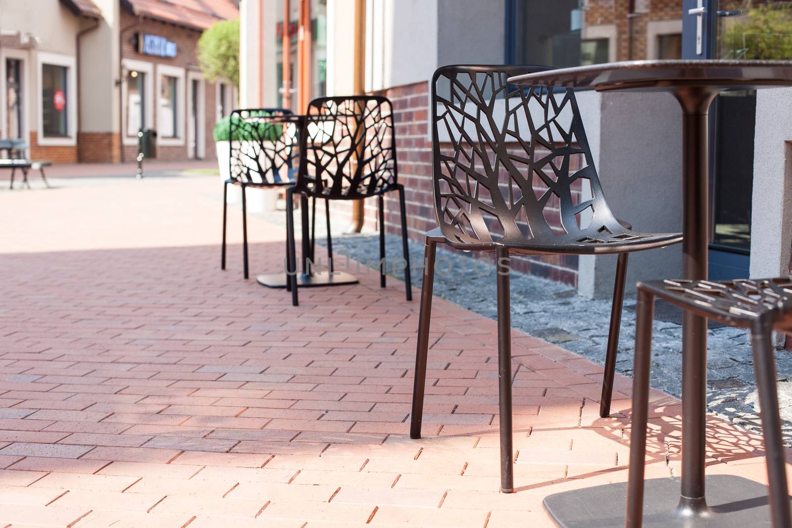 Modern carved chairs with trees in a cafe on the street