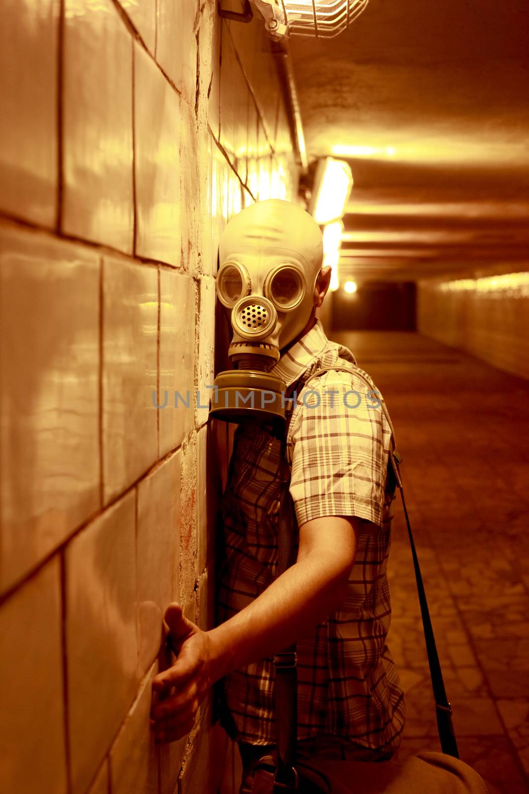 Man in a gas mask in the night tunnel