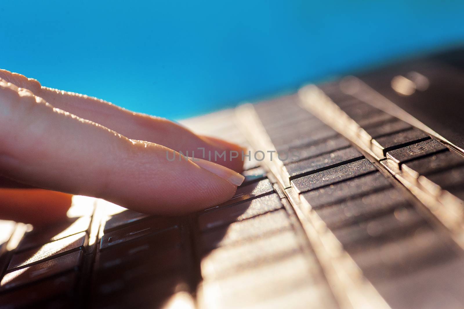 woman fingers on the keyboard of notebook by timonko