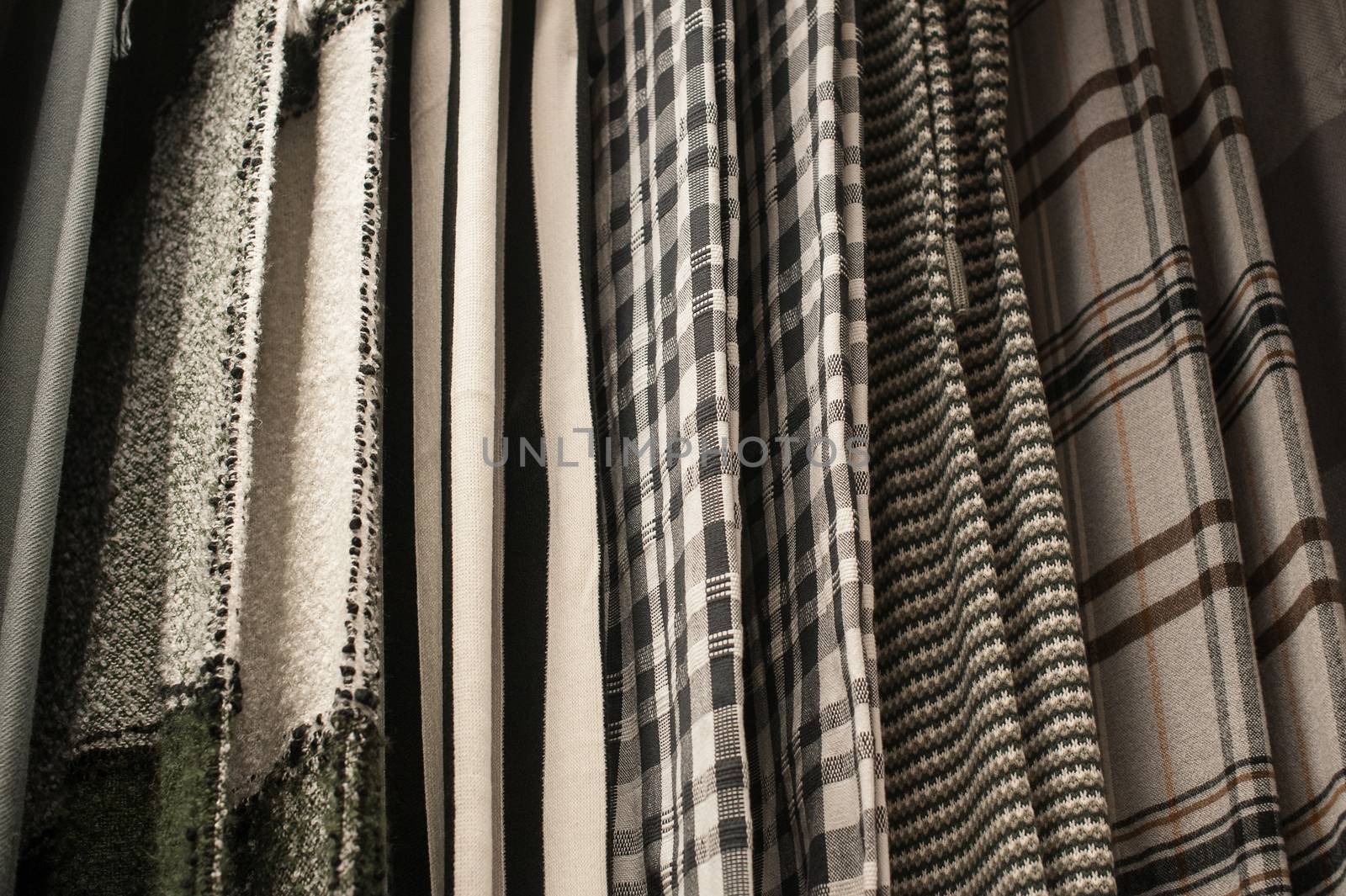 Texture sets of fabrics hang on the trempel in the closet.