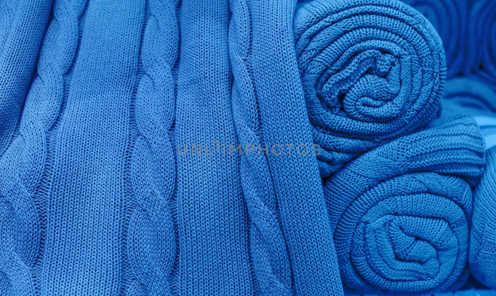 Blue knitted fabric twisted into a roll.