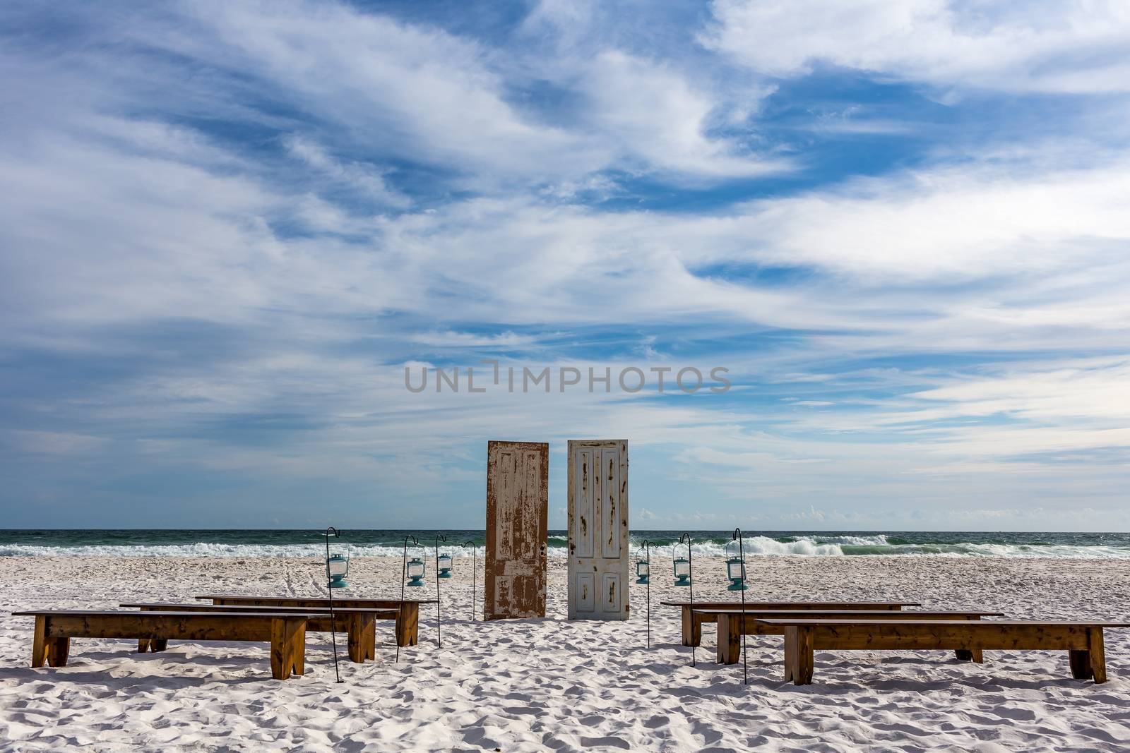 A conceptual design with doors, benches and lamps on the sand in front of the surf.