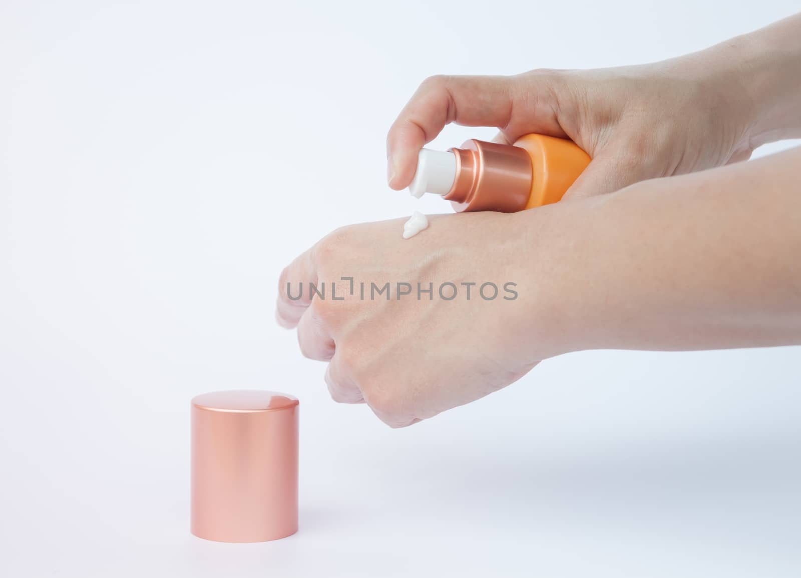 Woman hand holding cosmetic bottle isolated on white background by punsayaporn