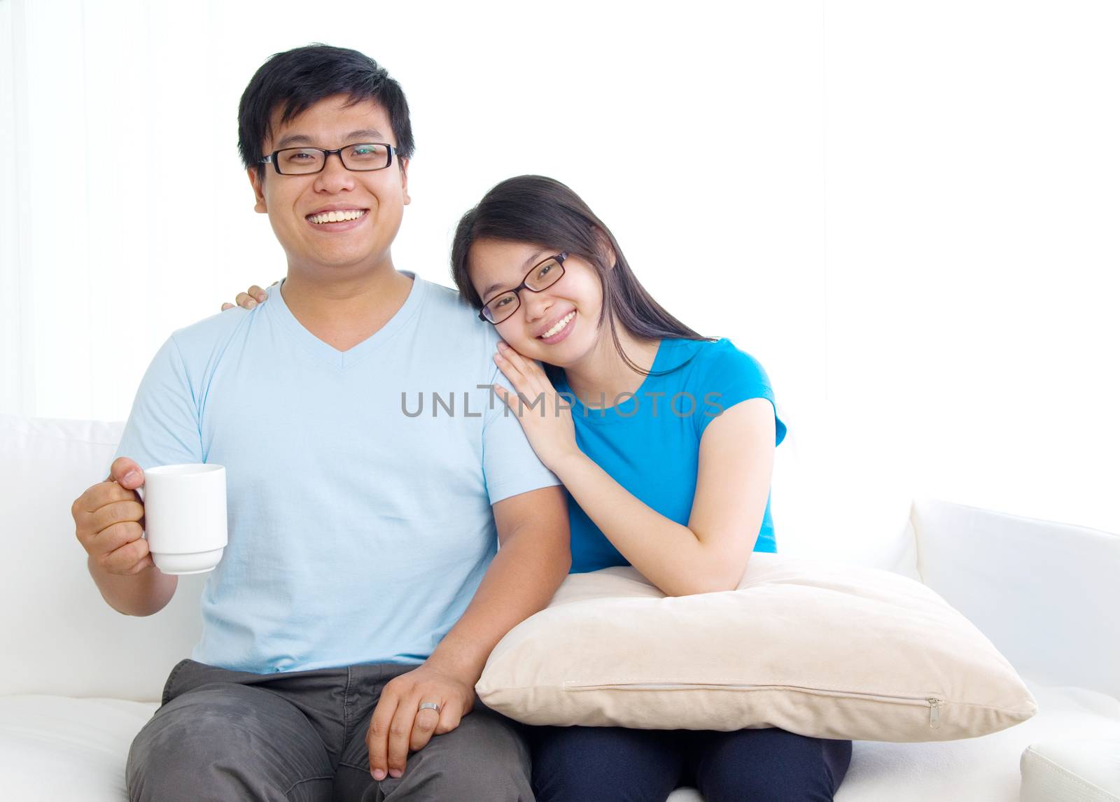 sweet young couple sitting in sofa