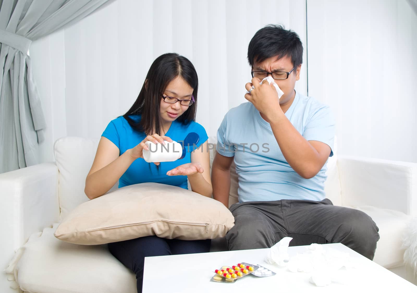 Asian man having medicine at home. Wife take care of her husband.