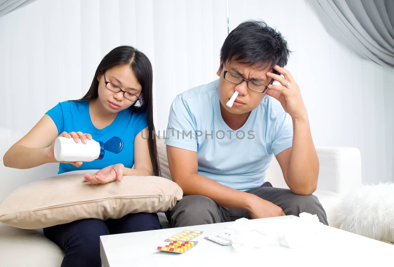 Asian man having medicine at home. Wife take care of her husband.