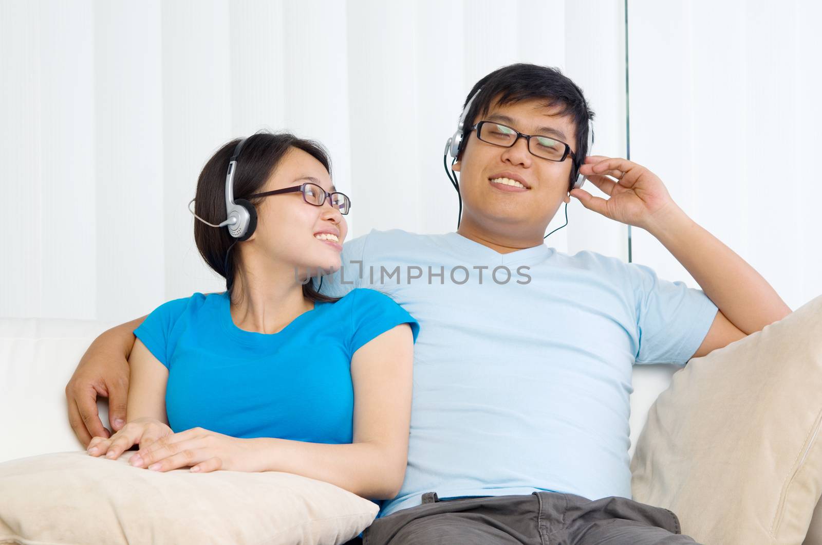 Relaxed young couple with headphones listening music