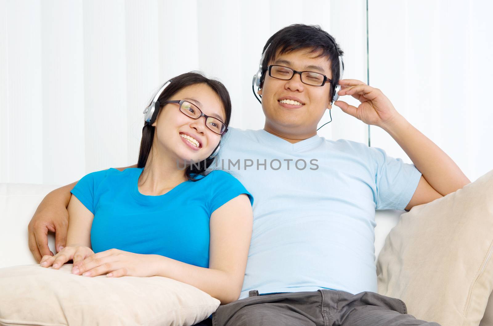 Relaxed young couple with headphones listening music