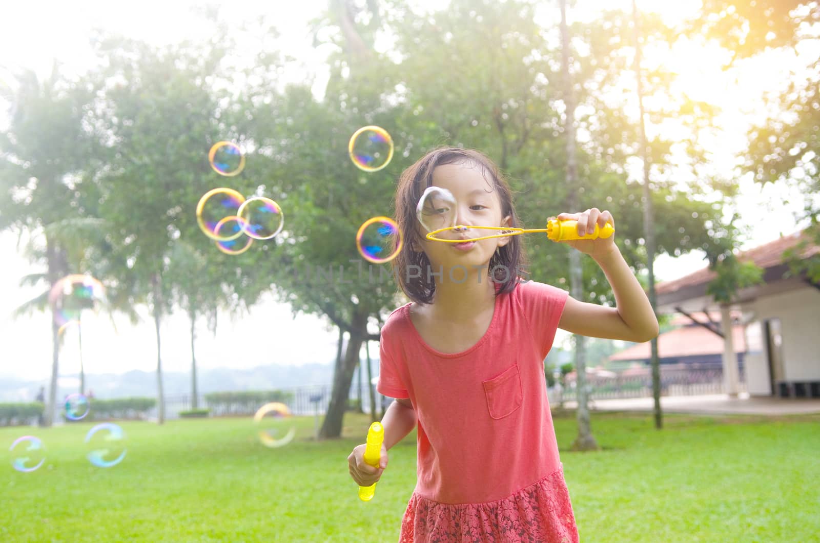 Asian girl blowing bubbles outdoor