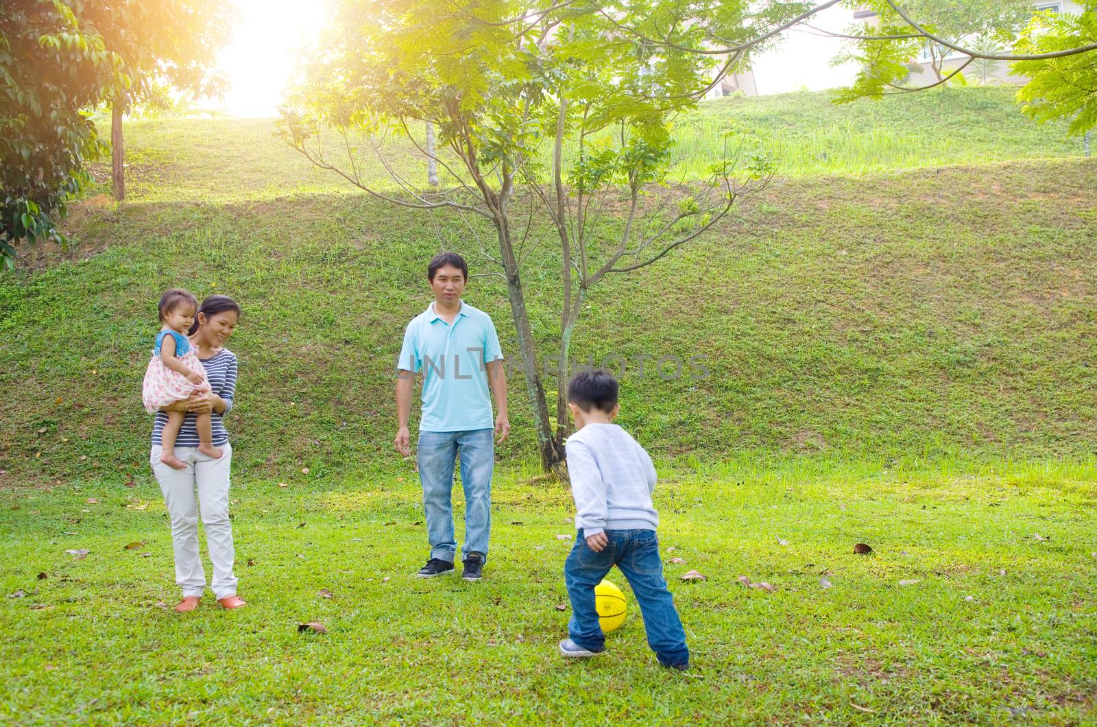 Asian family outdoor quality time enjoyment, asian people playing during beautiful sunset.