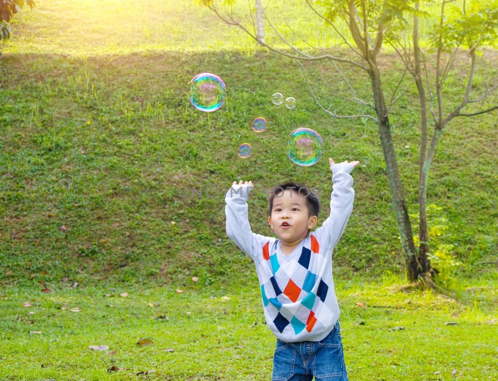 Asian boy playing bubbles outdoor