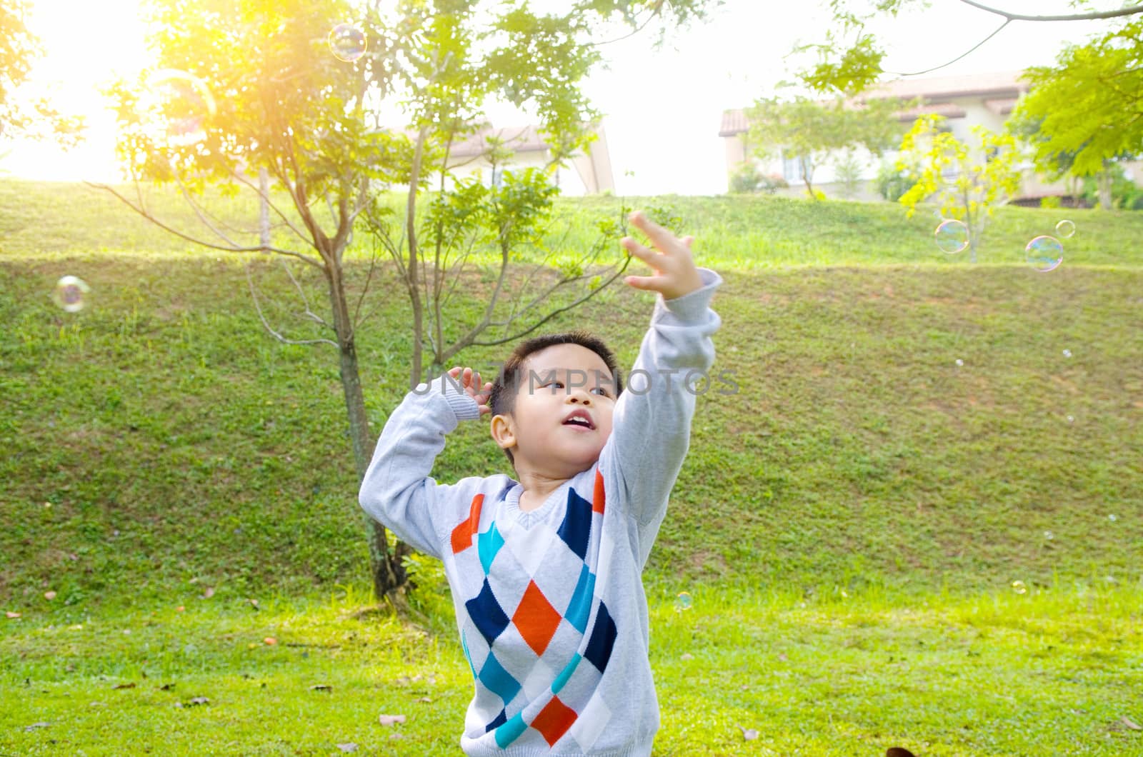 Asian boy playing bubbles outdoor