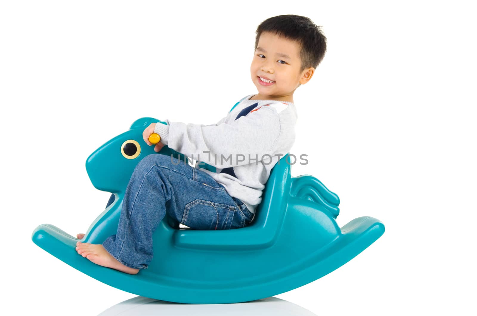 smiling asian boy playing with Toy horse