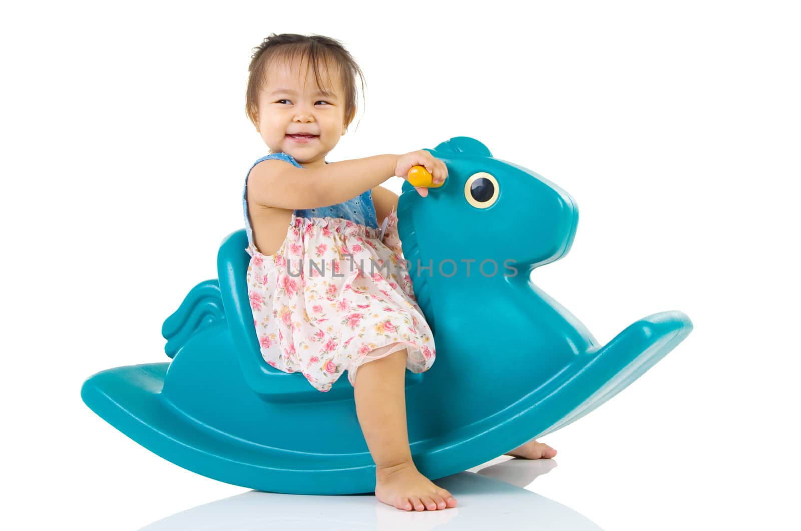 smiling asian girl playing with Toy horse