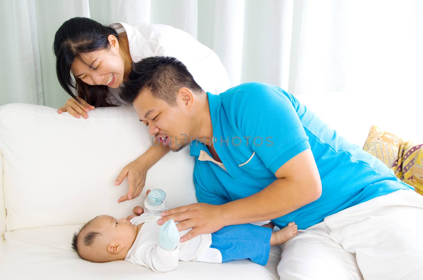 Asian family playing with their baby