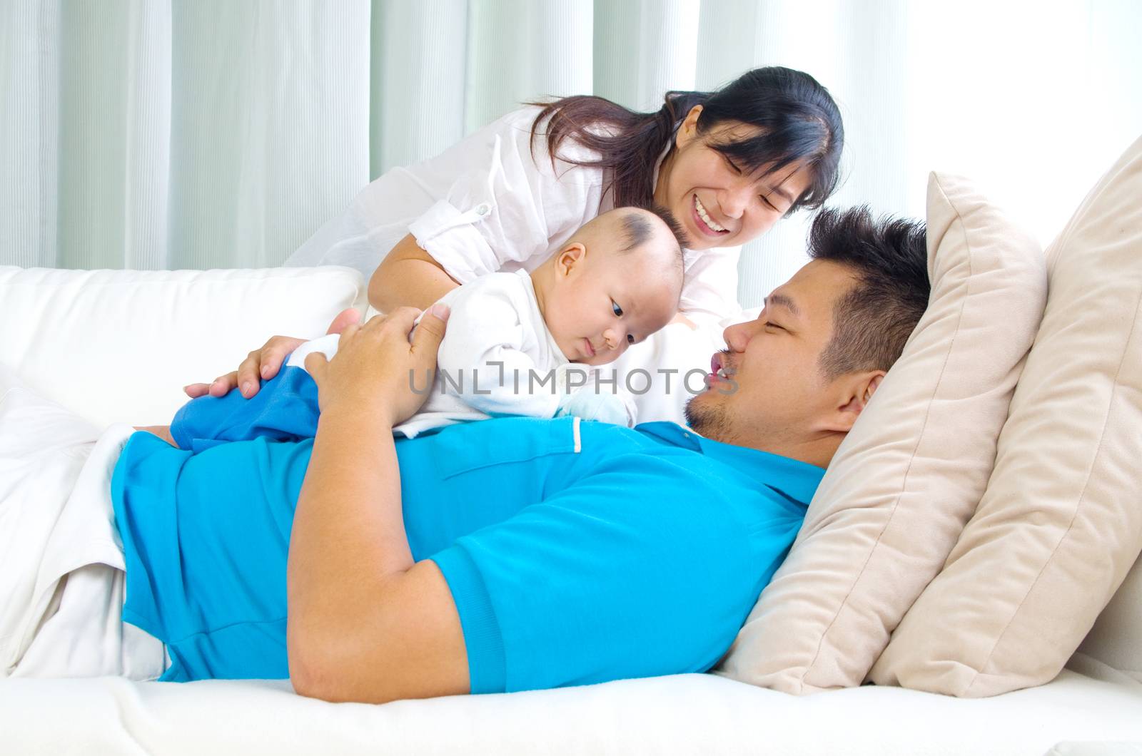 Asian family playing with their baby