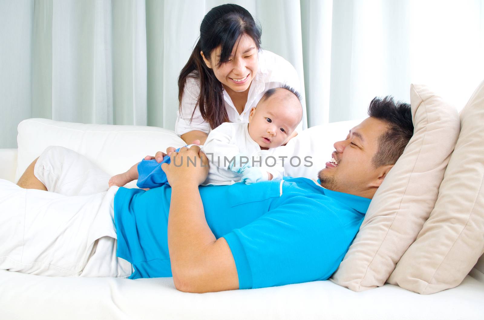 Asian family playing with their baby