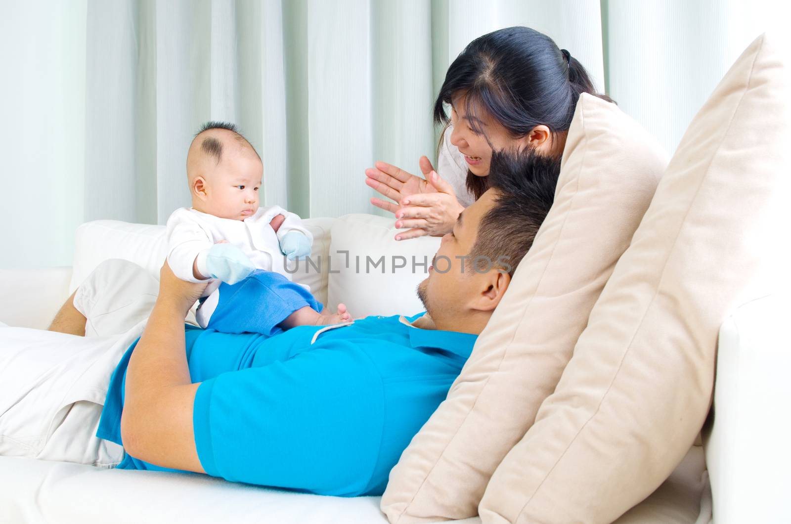Asian family playing with their baby
