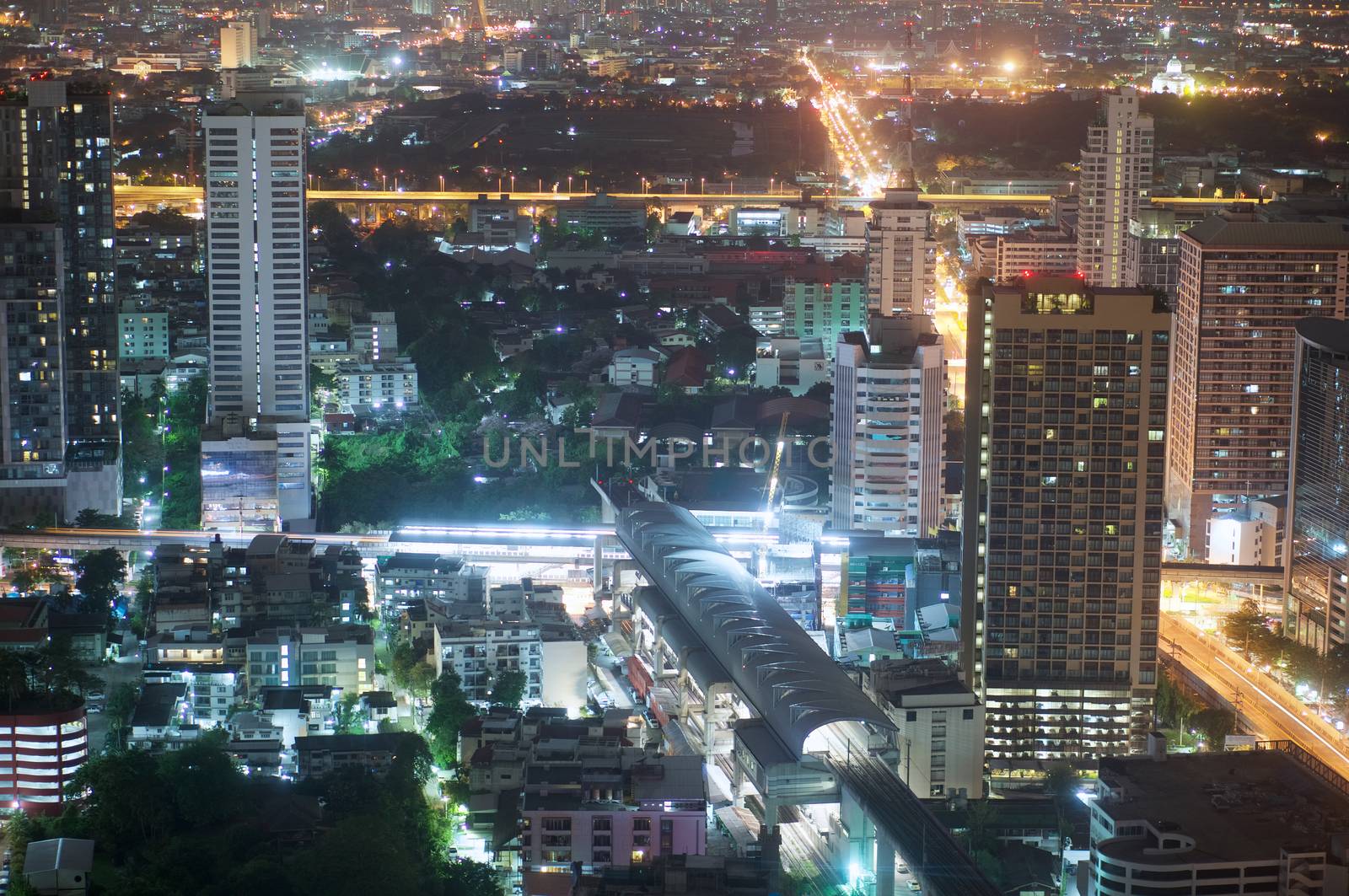 Airport link station and skyscrapers on city scape at night in Bangkok Thailand.