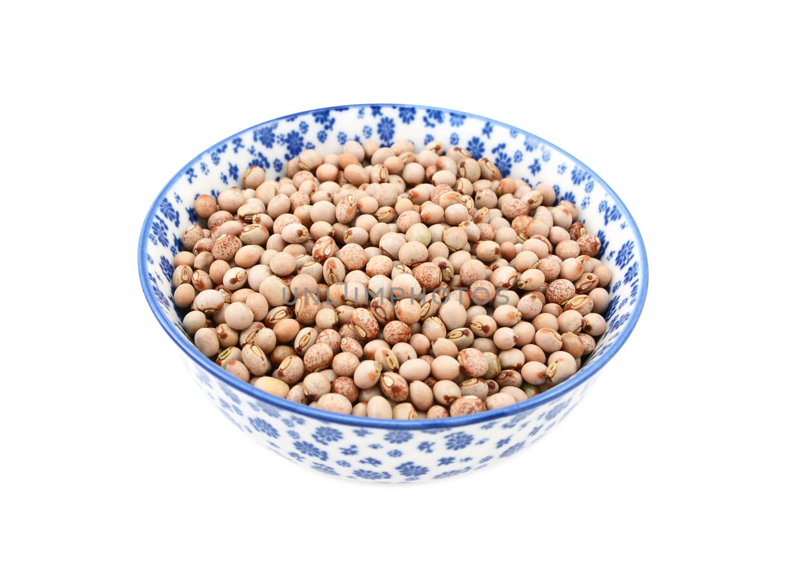 Pigeon peas in a blue and white porcelain bowl with a floral design, isolated on a white background