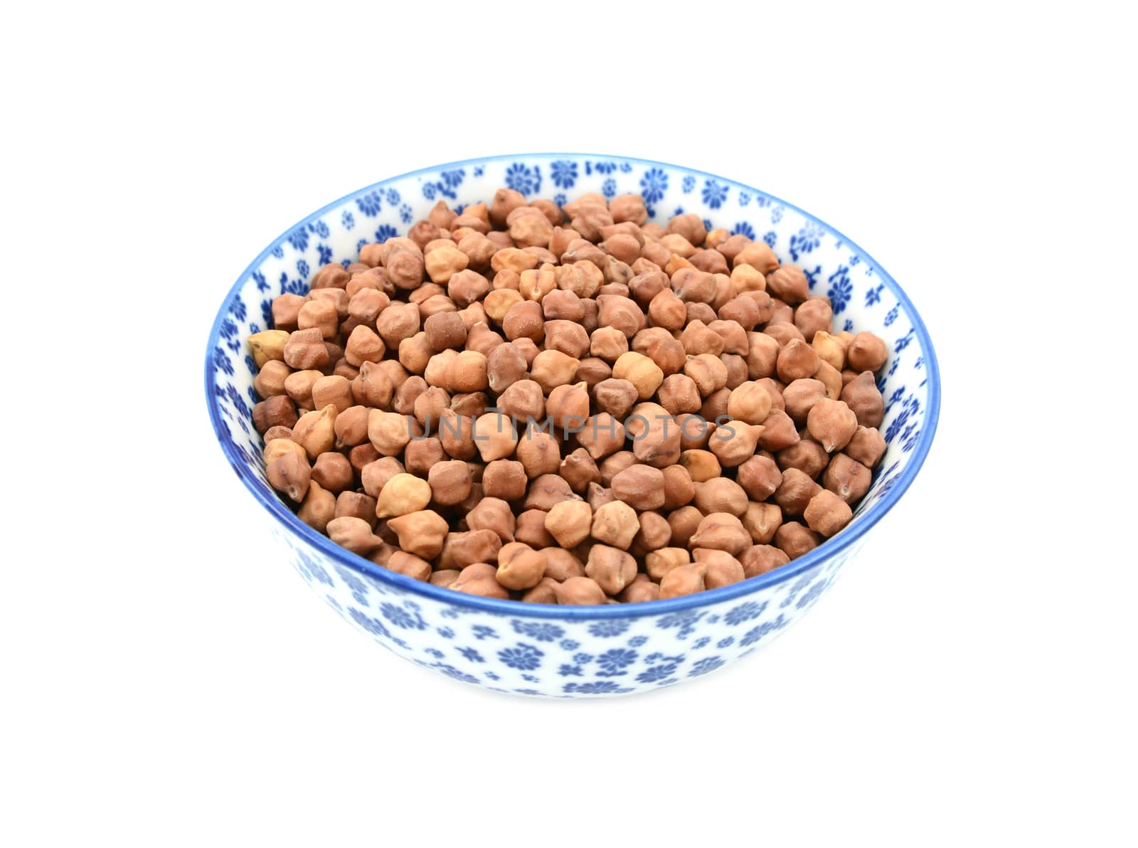 Black chickpeas in a blue and white porcelain bowl with a floral design, isolated on a white background