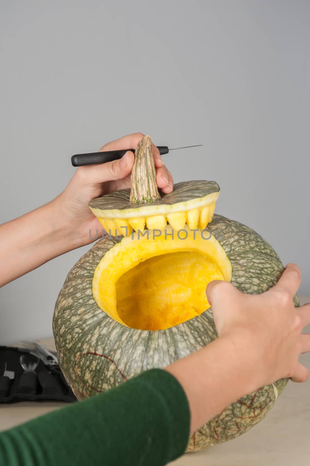 woman hands making pumpkin for halloween holidays.