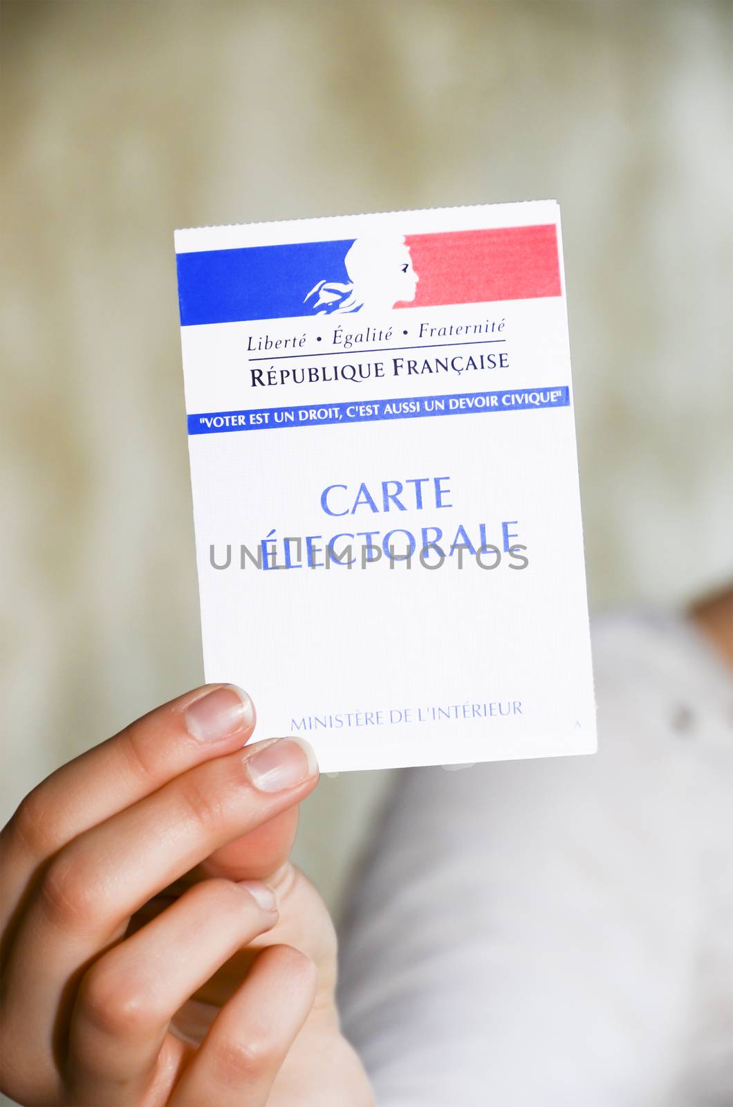 woman holding a french election card to vote in the presidential elections