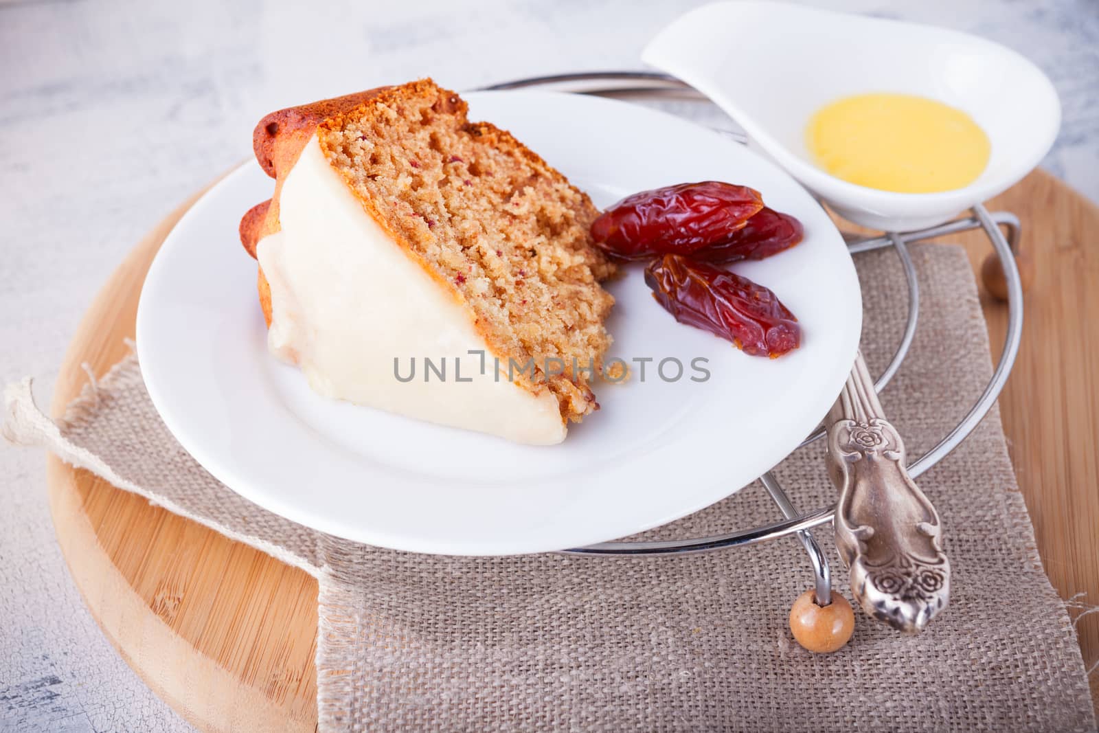 Slice of date cake and dates on a white plate
