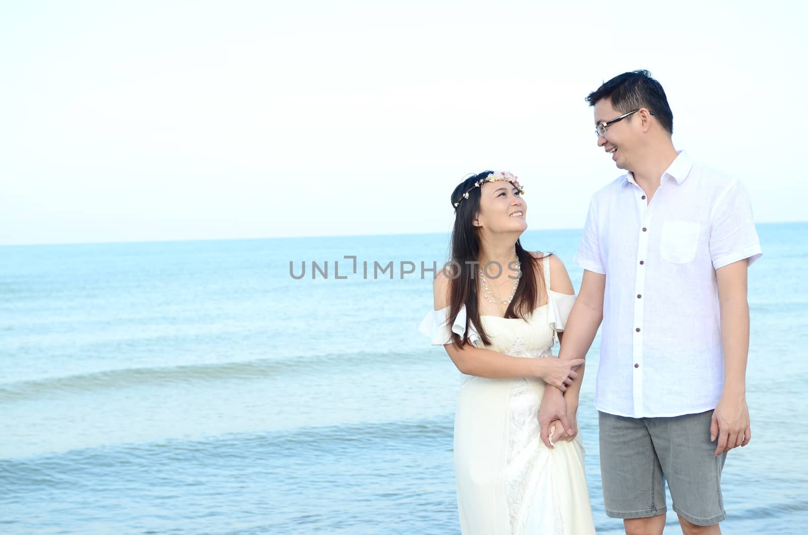 Asian bride and groom on a tropical beach. Wedding and honeymoon concept.