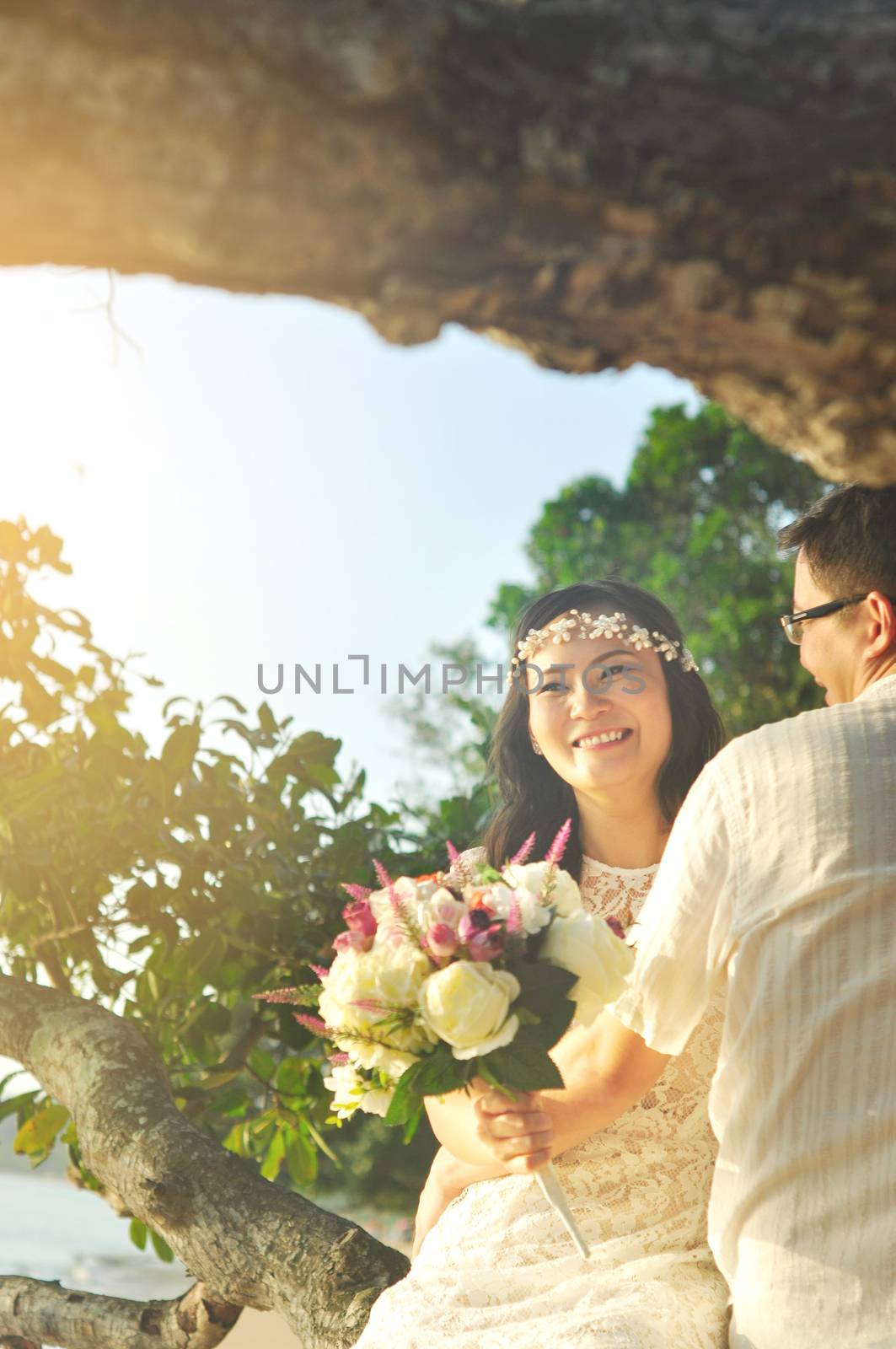 Outdoor Bride and groom on the beach with sunset in the evening.