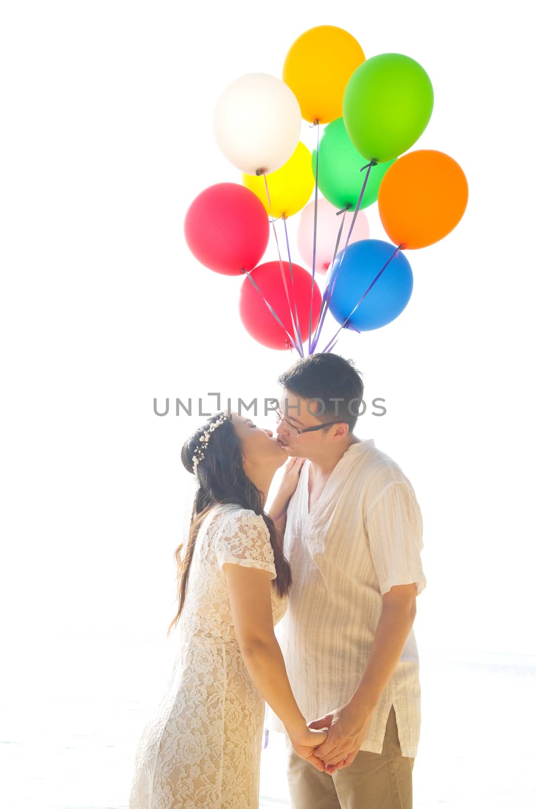 lovely asian couple kissing on the beach