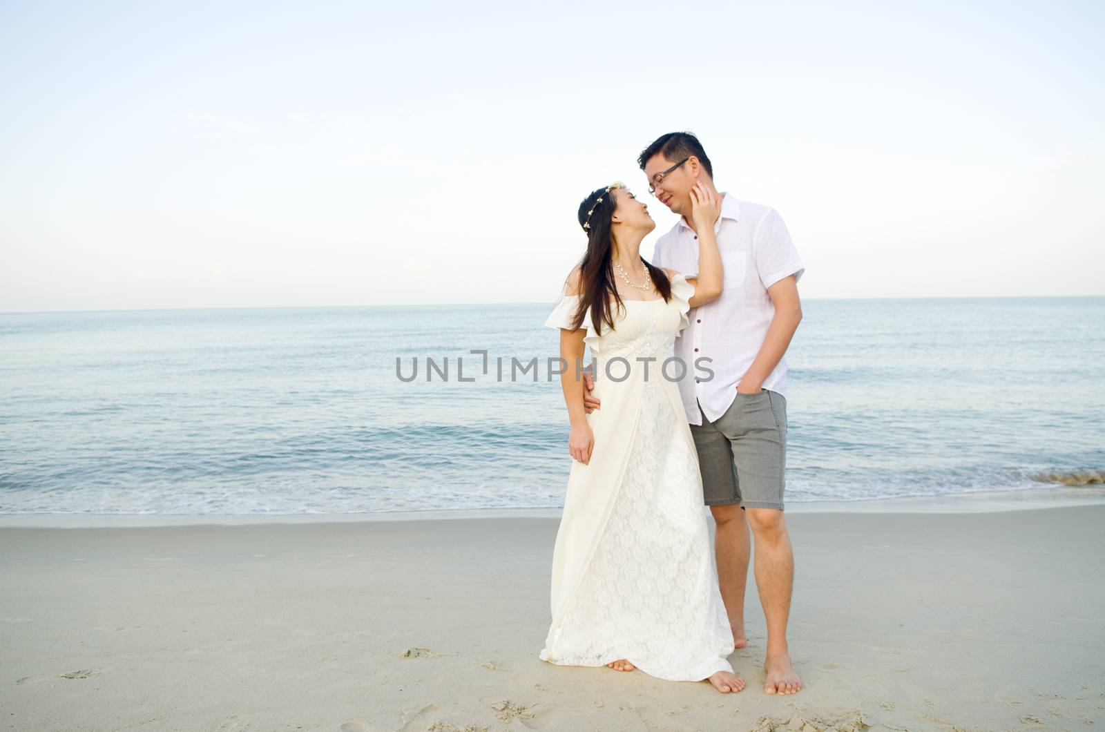 Asian bride and groom on a tropical beach. Wedding and honeymoon concept.