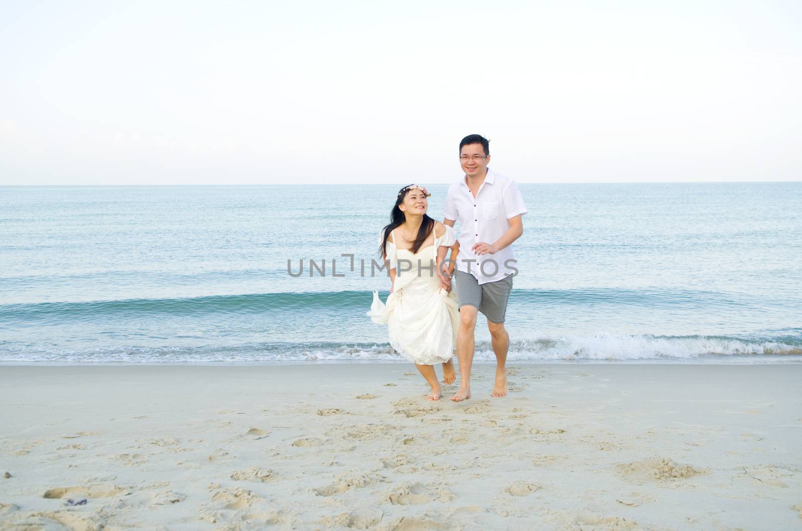 Asian bride and groom on a tropical beach. Wedding and honeymoon concept.