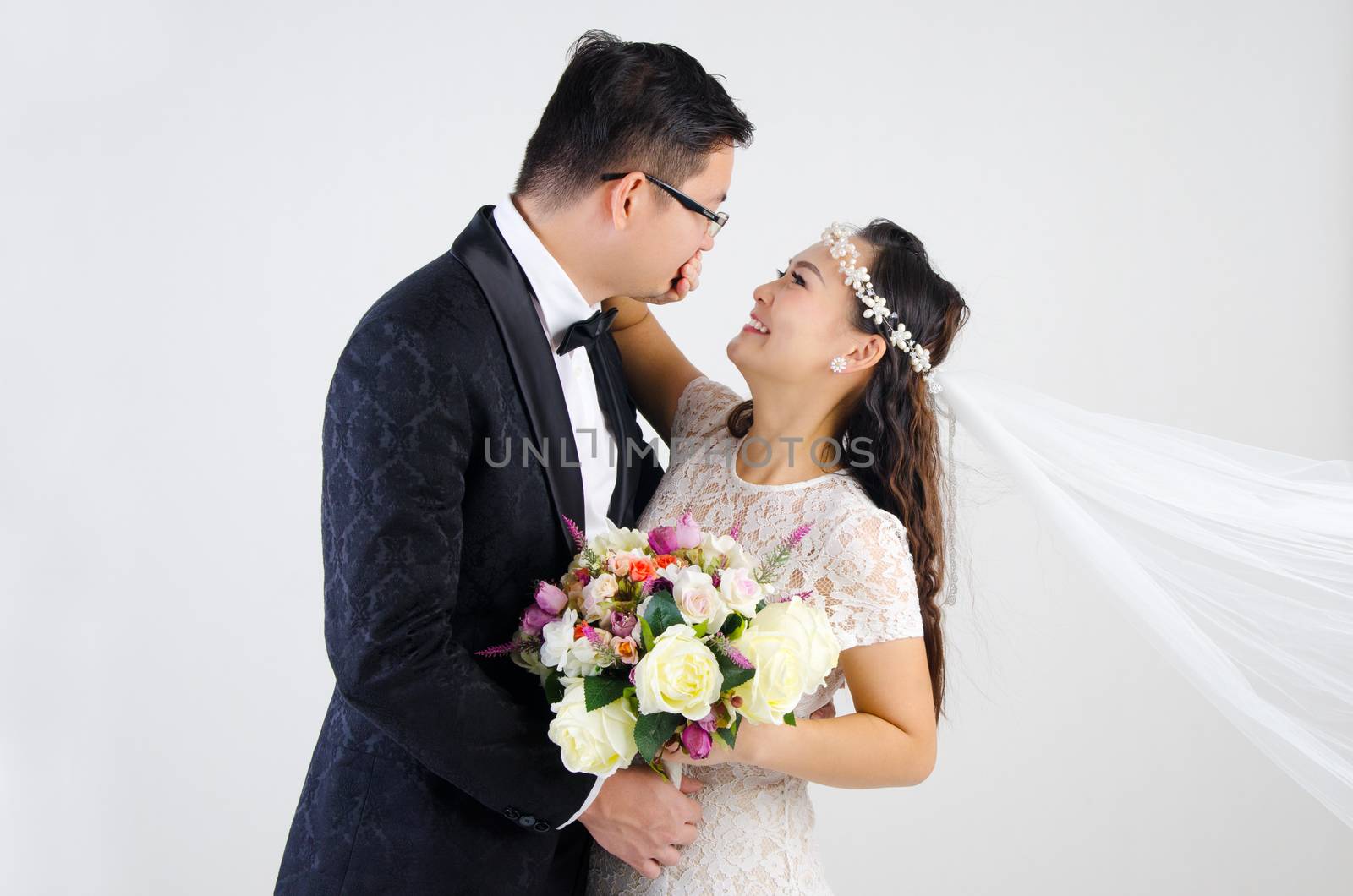 Attractive Bride and Groom at Wedding over grey background